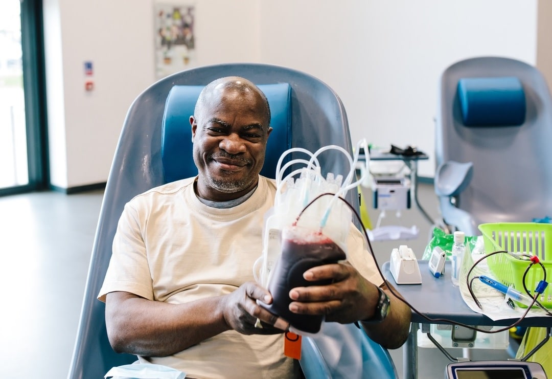 man-smiling-holding-donating-3-min